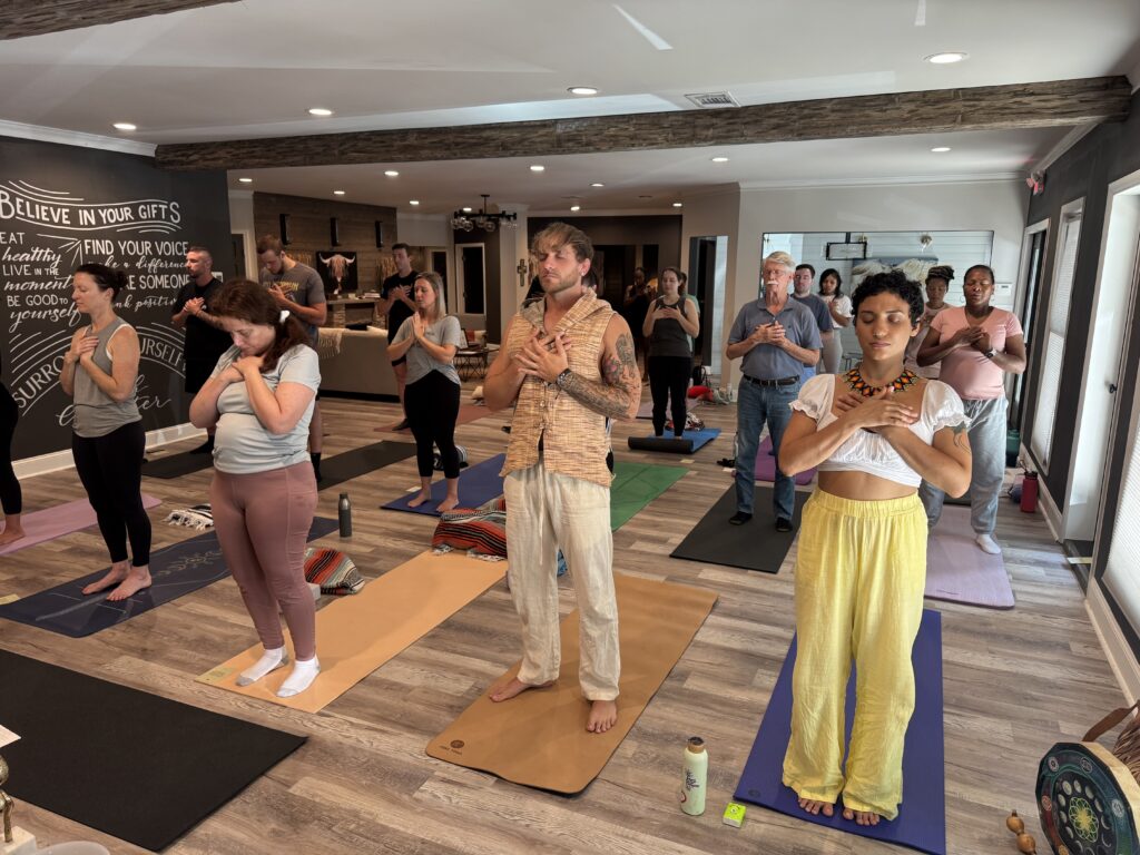 Yoga and breathwork group with hands on hearts, led by All Heart Holistic Group